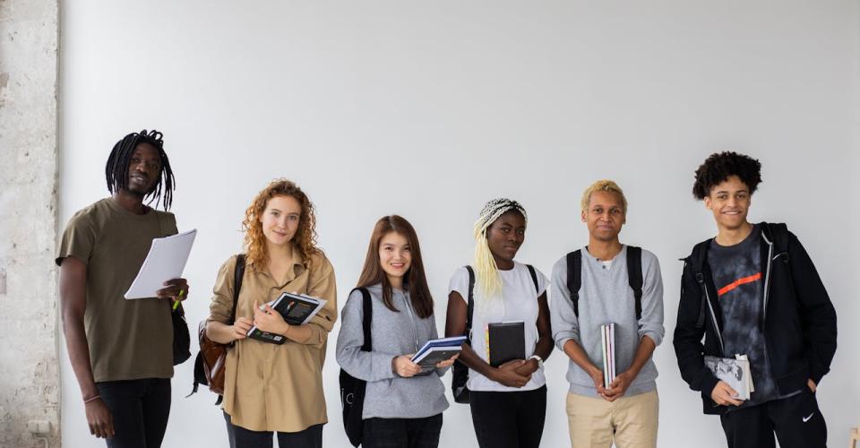 Photo de jeunes portant des livres et des cahiers